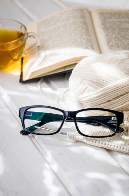 Staršie knihy o ručných prácach položené vedľa vyšívaného krojového dielu