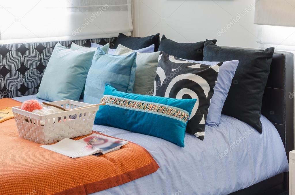 Háčkované deky a vankúše rozložené na gauči s otvorenou knihou